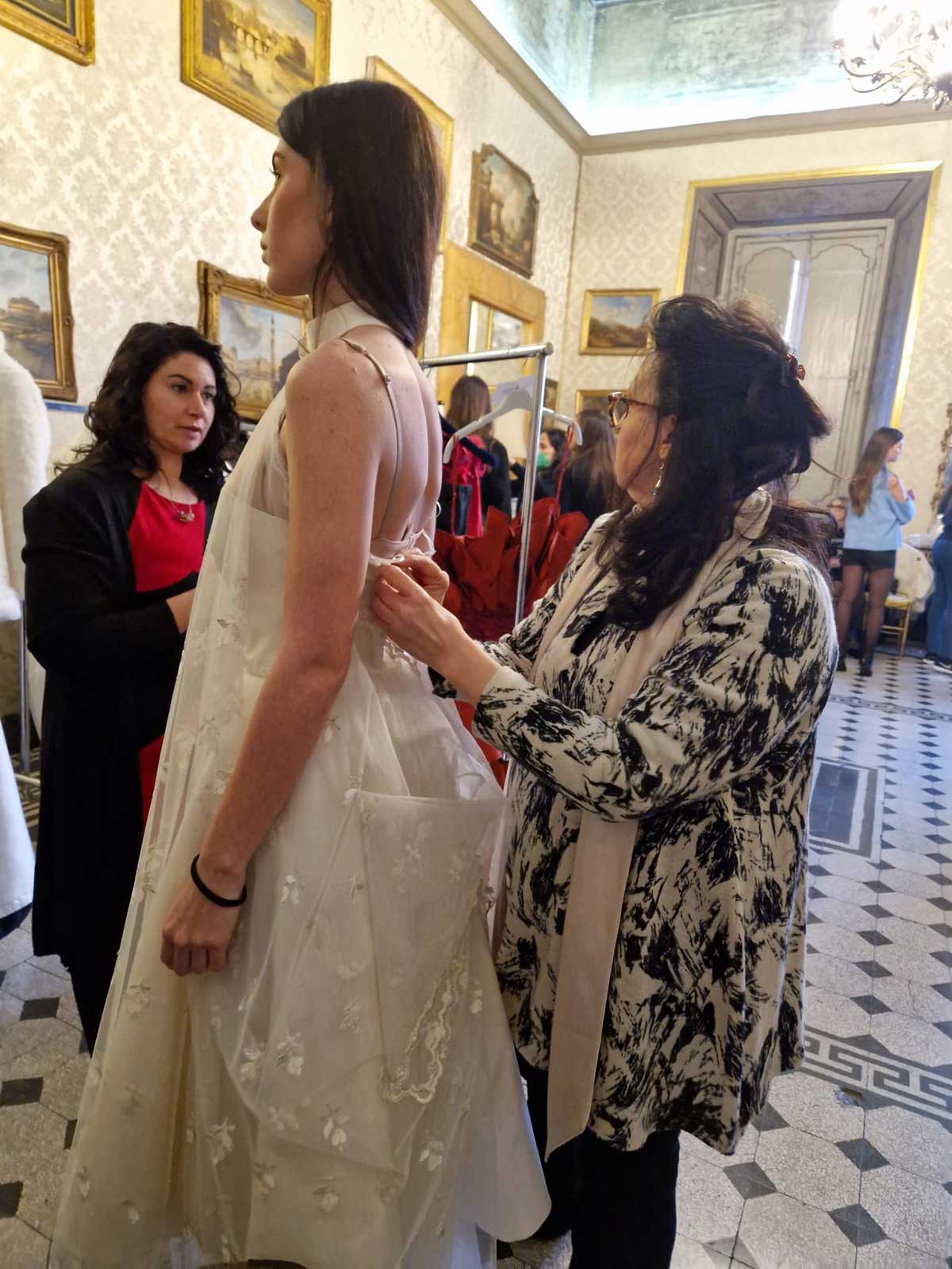 Sfilata abiti donna modelle a Palazzo Ferrajoli - Elins Moda - stilista veste modella con abito matrimonio sposa
