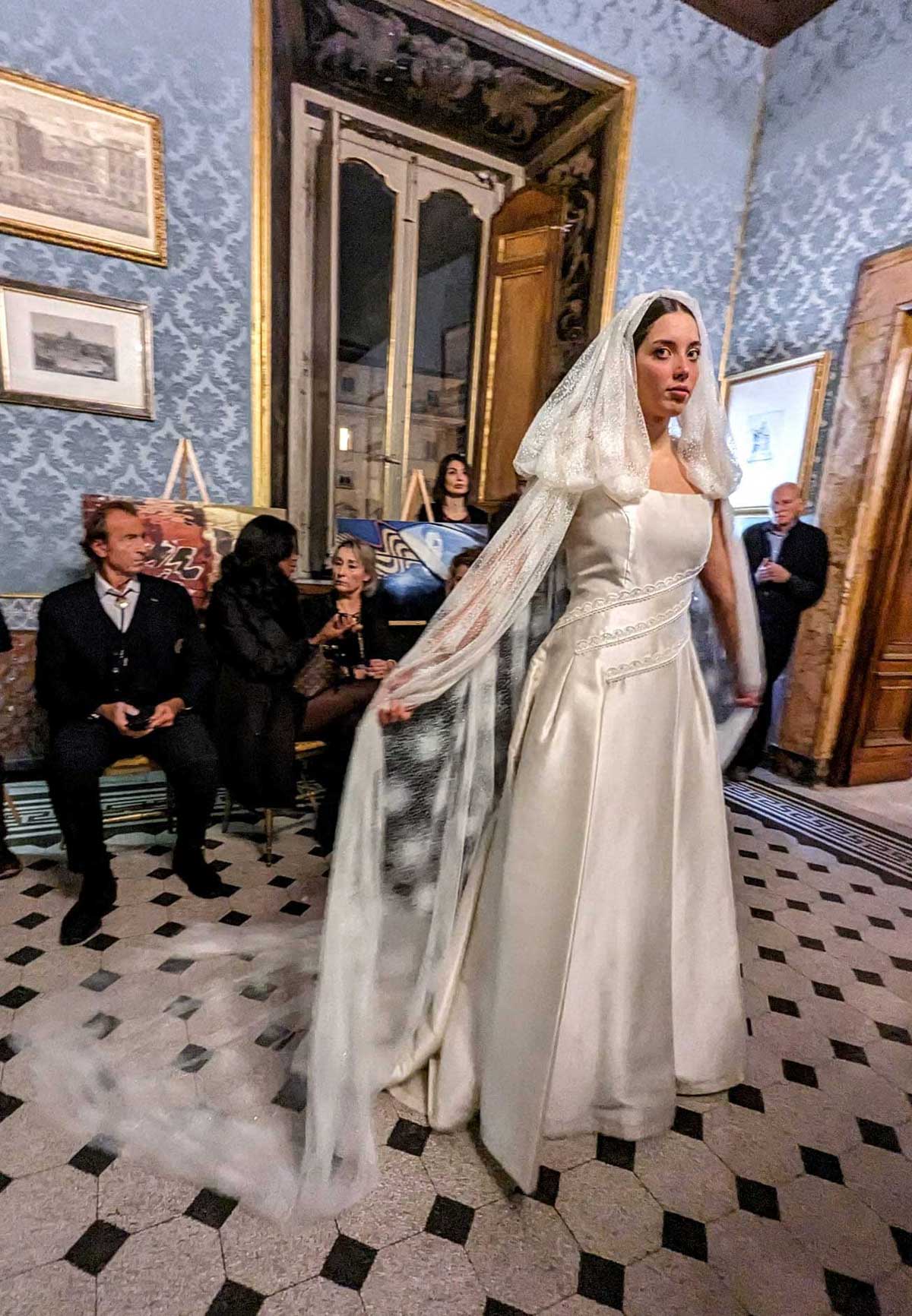 modella sfila in abito da sposa con velo