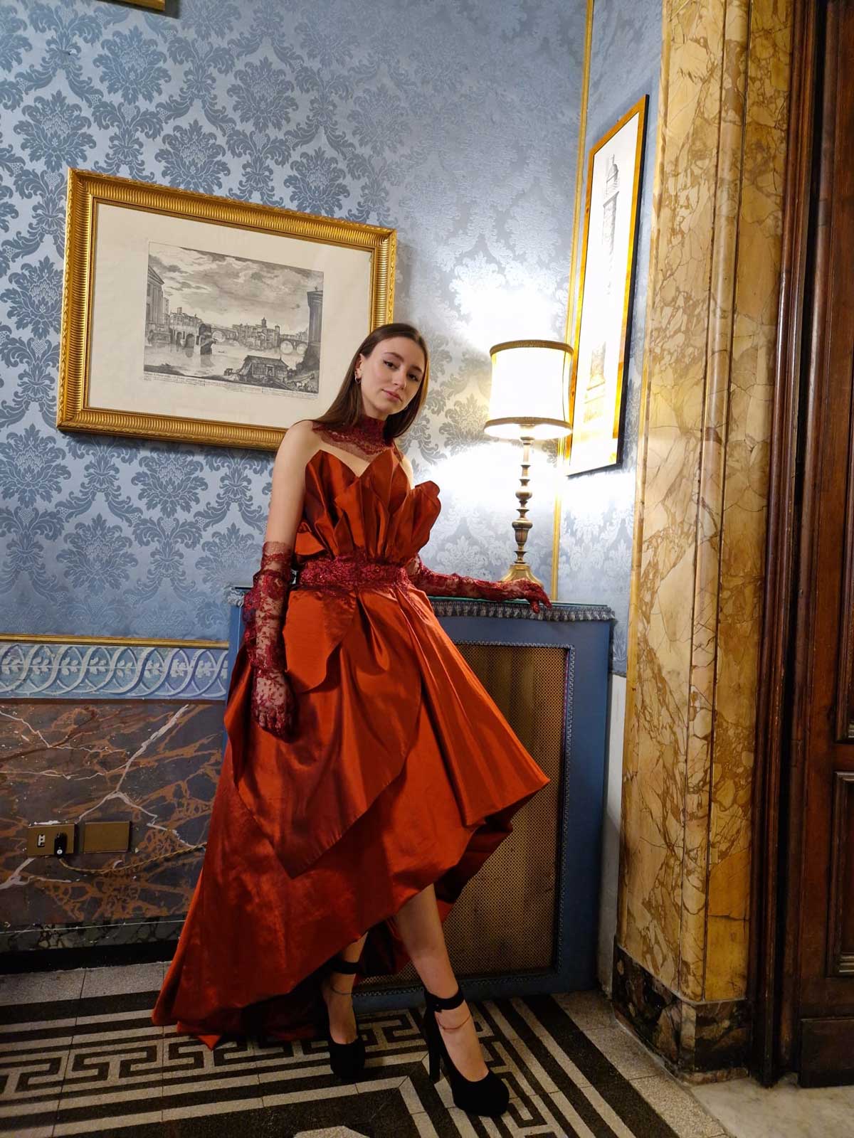 Palazzo Ferrajoli ragazza vestita in rosso bruno